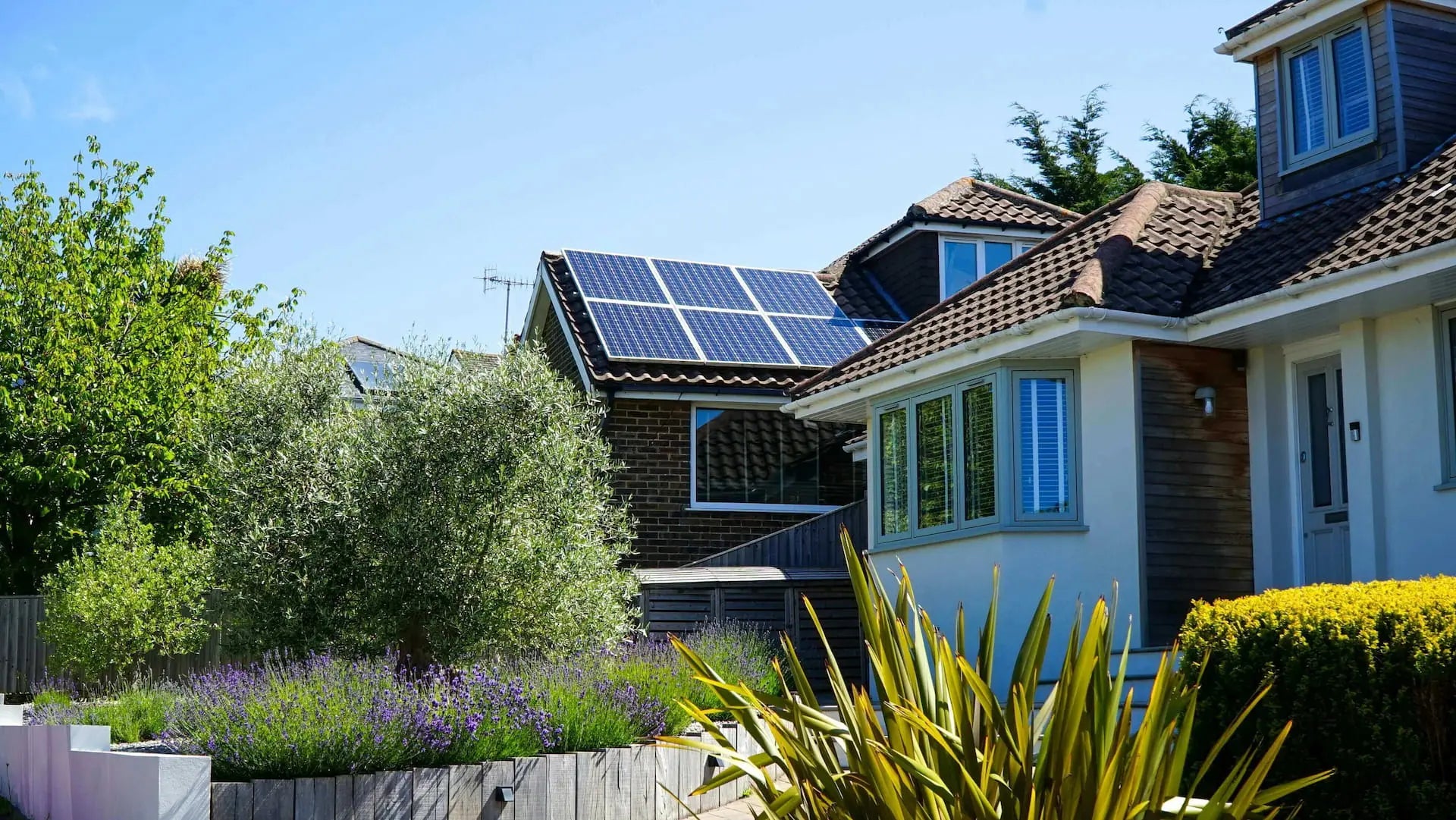 Solar power system installation in Durban - energy-efficient home with roof-mounted solar panels surrounded by greenery.