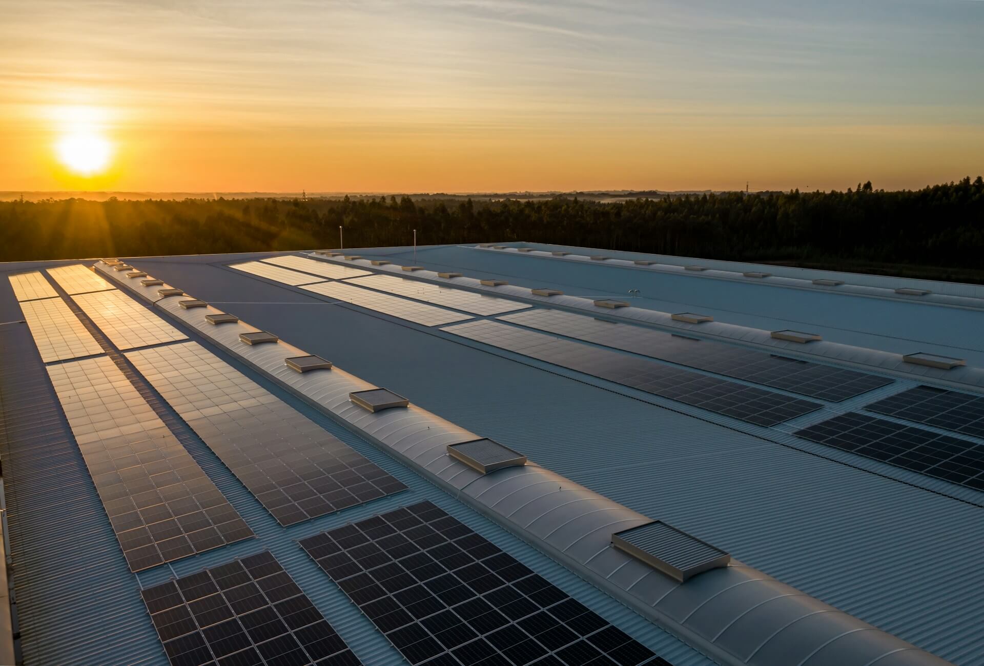 Solar panels on a roof with a sunset in the background