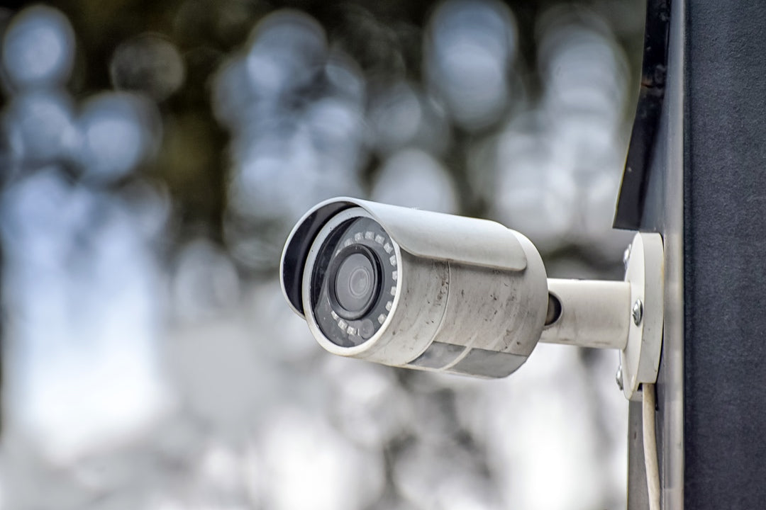 CCTV Security camera mounted on a wall with a blurred background